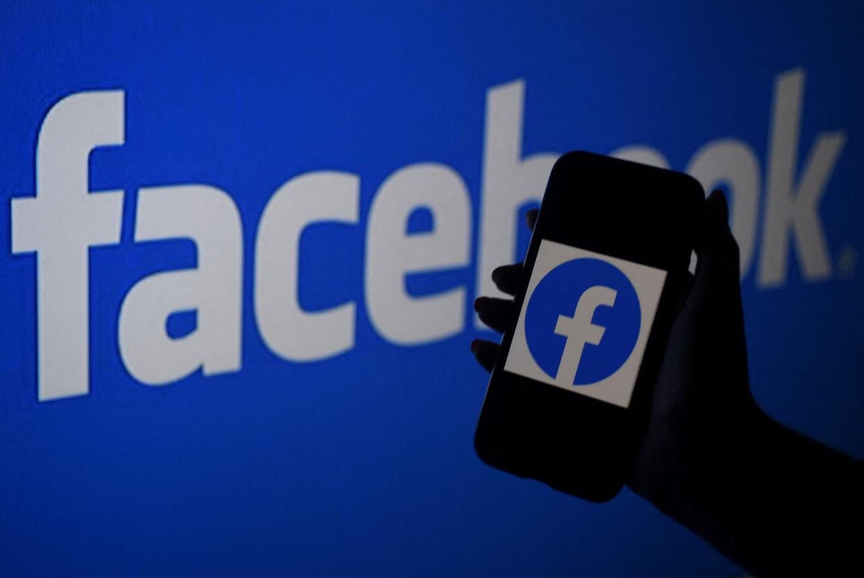 A smart phone screen displays the logo of Facebook on a Facebook website background (AFP via Getty Images)