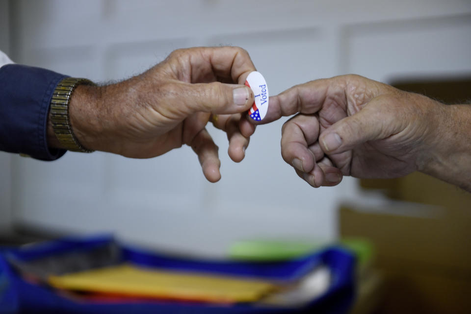 A poll volunteer hands out an 'I Voted' sticker at a rural polling place during the U.S. presidential election in Stillwater, Oklahoma,&nbsp;on Nov. 8.