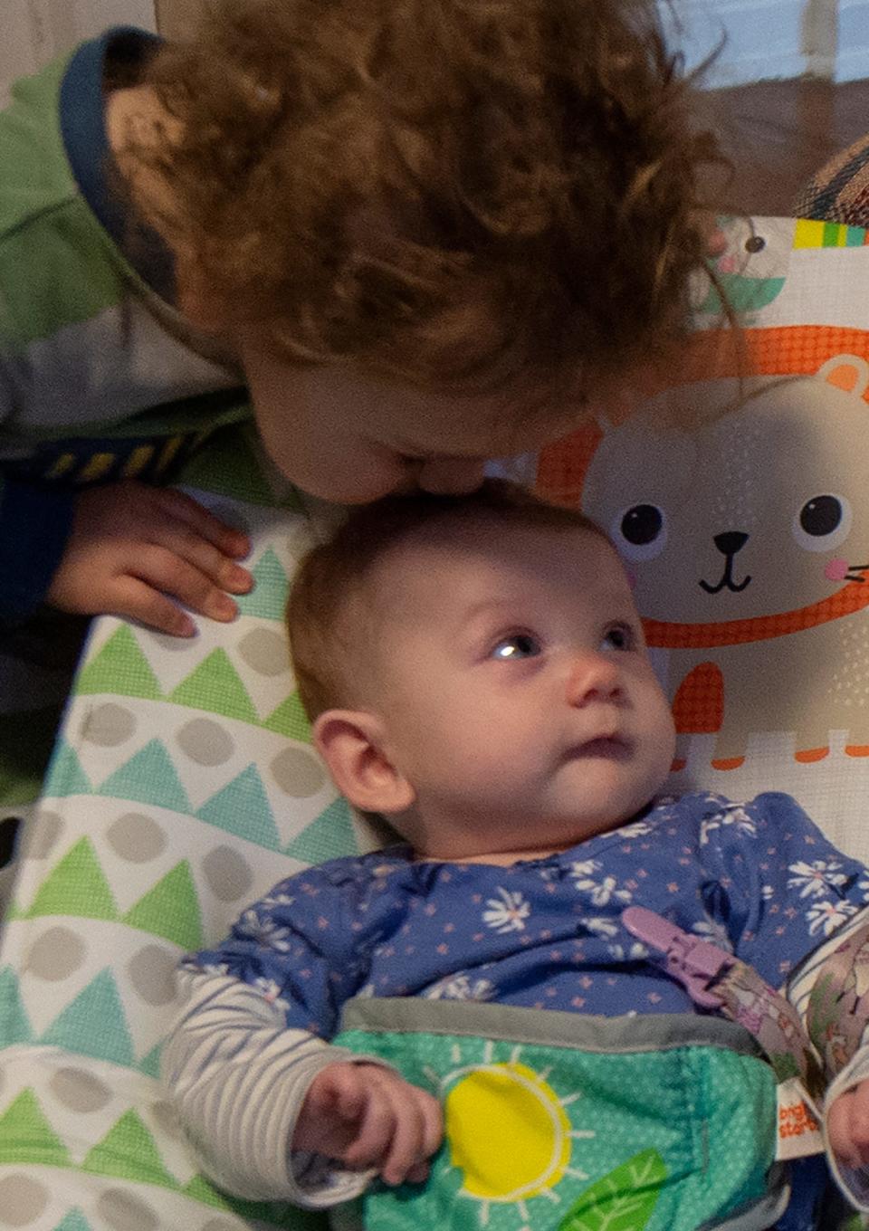 Noah, 15 months, gives his littlewsister, Annalyce, three months a kiss, Friday, nov. 18, 2022.