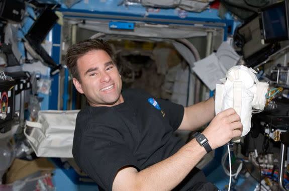 Astronaut Greg Chamitoff, Expedition 17 flight engineer, takes a moment for a photo as he works in the Destiny laboratory of the International Space Station while Space Shuttle Discovery is docked with the station in 2008.