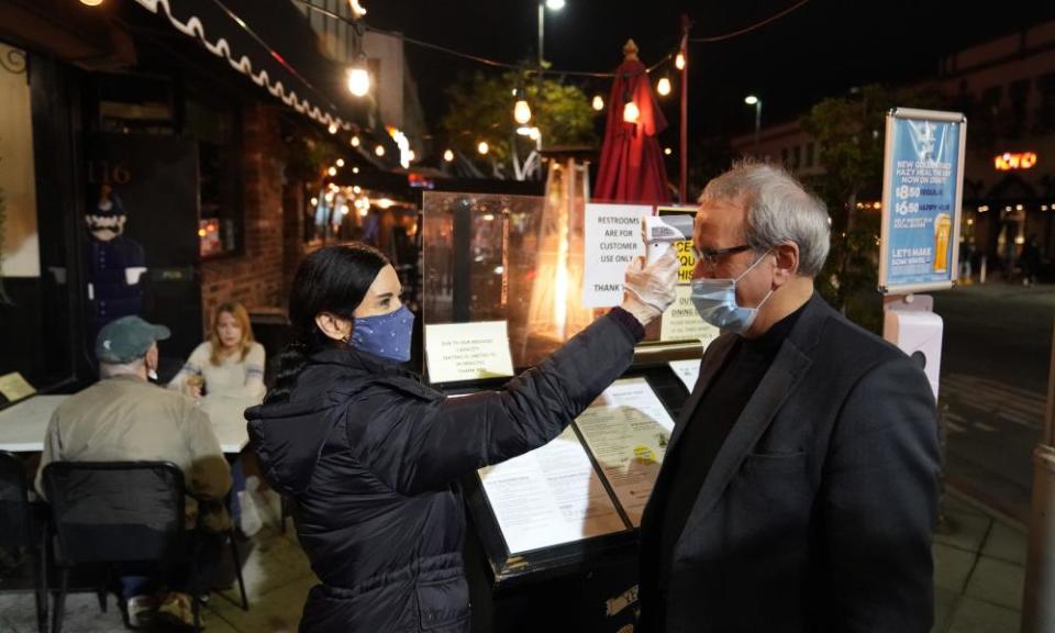 A hostess takes a customer’s temperature at Ye Olde King’s Head in Santa Monica last month.