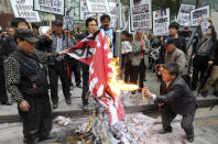 FILE - In this April 25, 2013, file photo, members from conservative civic organizations burn a Japanese rising sun flag during a rally to protest Japanese lawmakers who made a visit to Yasukuni Shrine in Tokyo, in front of Japanese Embassy in Seoul, South Korea. Japan’s “rising sun” flag is raising anger at the Olympics, with some of the host nation’s neighbors calling for it to be banned during the Tokyo Games, which start Friday, July 23, 2021. (Lee Jung-hoon/Yonhap via AP, File)