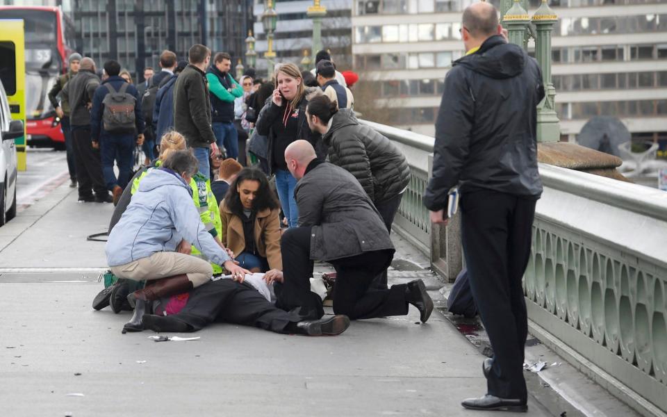 Injured people are helped on Westminster Bridge  - Credit: TOBY MELVILLE / REUTERS