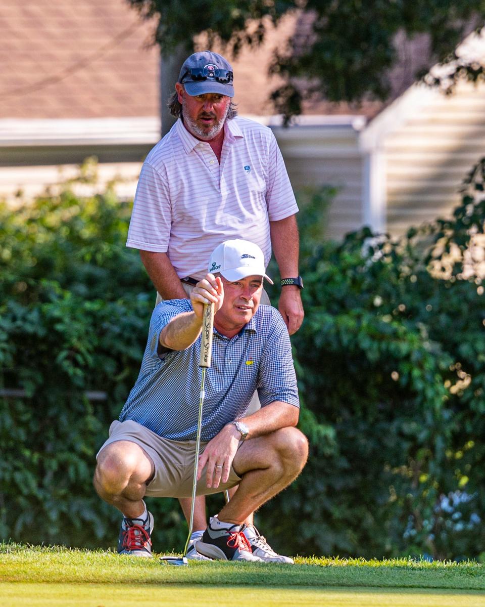 Adam Fernandes and Jason Hantman study the eigth green at the CCNB Fourball Tournament.