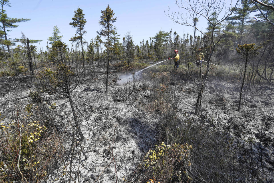 Department of Natural Resources and Renewables firefighters Walter Scott, left, and Zac Simpson work on a fire in Shelburne County, Nova Scotia onThursday, June 1, 2023. (Communications Nova Scotia /The Canadian Press via AP)