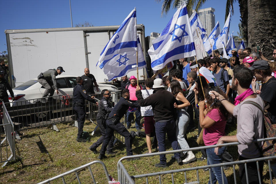 Israeli police scuffle with protesters as they try to block a main road to protest against plans by Prime Minister Benjamin Netanyahu's new government to overhaul the judicial system, in Tel Aviv, Israel, Thursday, March 9, 2023. (AP Photo/Ohad Zwigenberg)