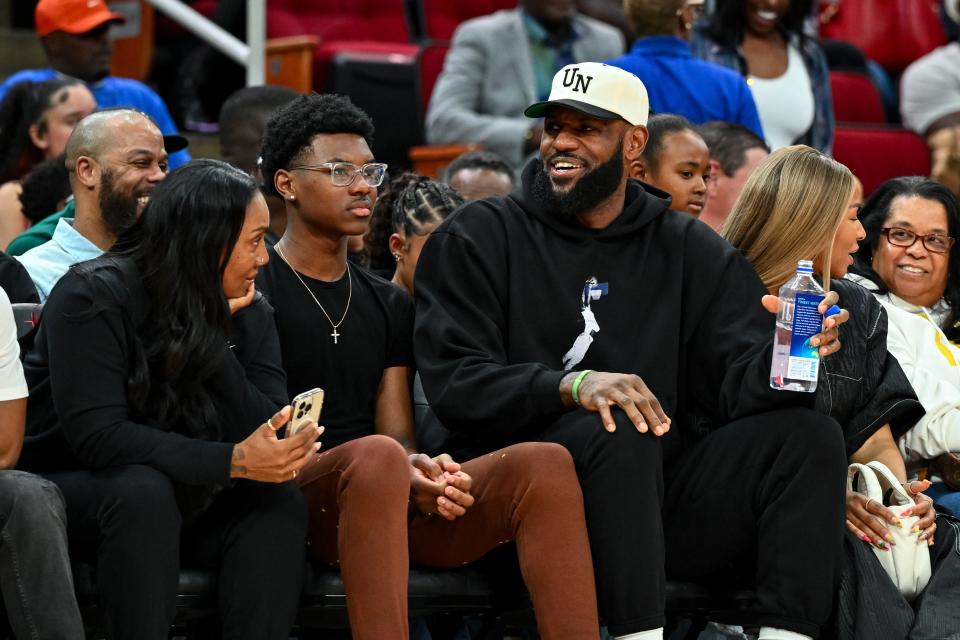 Los Angeles Lakers forward LeBron James sits with his wife Savannah James (right), son Bryce Maximus James (left) and his mother Gloria Marie James (left) court side of the between the McDonald's All American East and the McDonald's All American West at Toyota Center on Mar 28, 2023.