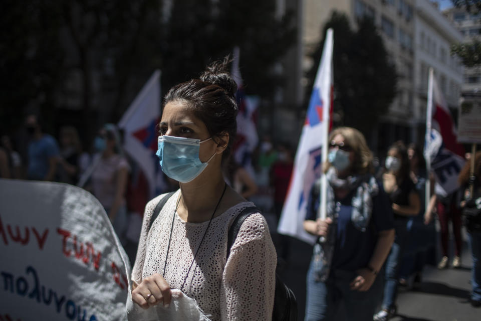 Greek state school teachers and students, wearing masks to prevent the spread of the coronavirus, protest in Athens, on Wednesday, May 13, 2020. Unions oppose government plans to allow remote teaching with use of a camera that will show the blackboard as part of the government's response to the coronavirus pandemic .(AP Photo/Petros Giannakouris)