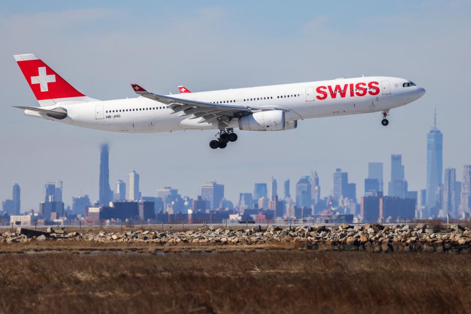 An Airbus A330 passenger aircraft of Swiss airlines arrives from Zurich at JFK International Airport in New York as the Manhattan skyline looms in the background on February 7, 2024.