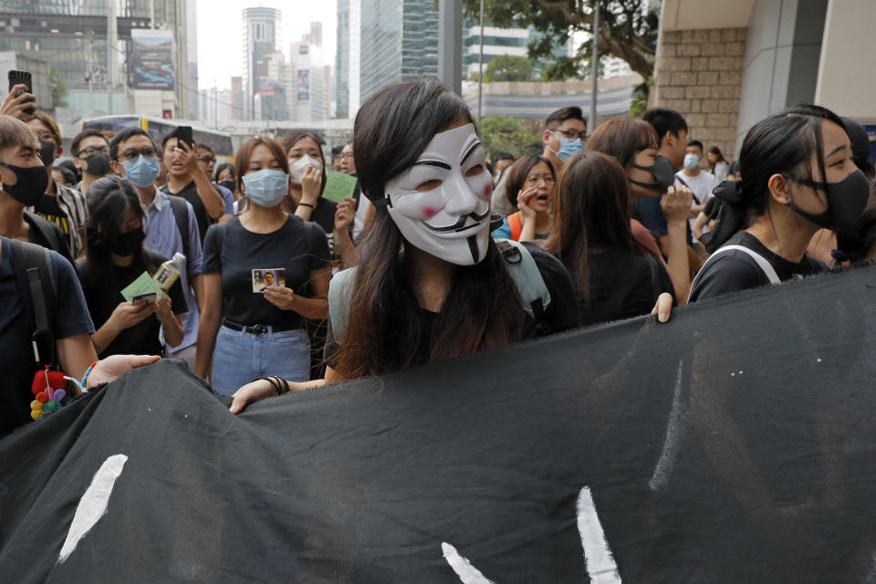 Supporters of Hong Kong activist Edward Leung gather outside the High Court in Hong Kong, Wednesday, Oct. 9, 2019. Last year, Leung was sentenced to six years in prison for his part in a violent nightlong clash with police over illegal street food hawkers two years ago. (AP Photo/Kin Cheung)