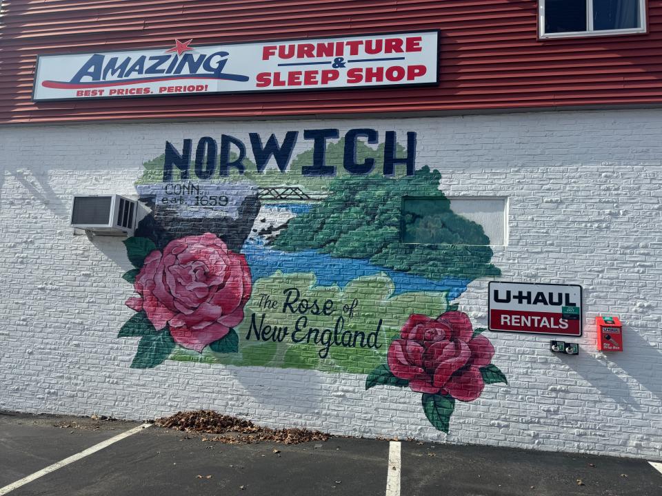 A painting with "The Rose of New England" nickname on the side of Amazing Furniture & Sleep Shop on Main Street in Norwich.