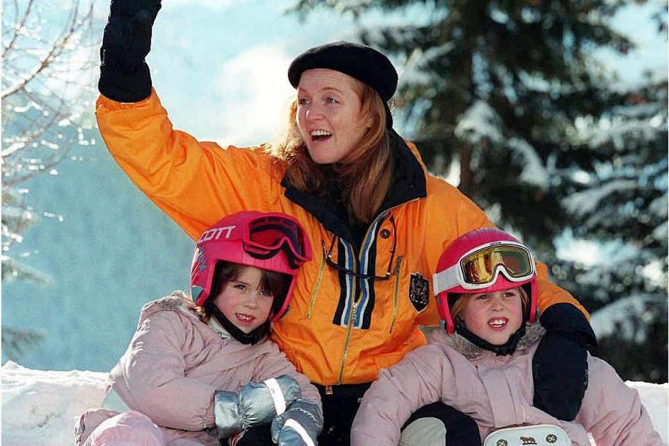 The Duchess of York, Sarah Ferguson, waves to friends as she poses for photographers with her daughters, Beatrice (R) and Eugenie, in the ski resort of Verbier (PA Images)