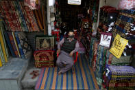 A shopkeeper wears a mask as a precautionary measure against the spread of the new coronavirus while he waits for customers at his shop, in Peshawar, Pakistan, Monday, March 16, 2020. For most people, the new coronavirus causes only mild or moderate symptoms. For some it can cause more severe illness. (AP Photo/Mohammad Sajjad)