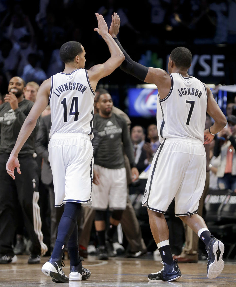 Brooklyn Nets guard Shaun Livingston (14) and guard Joe Johnson (7) high-five as they walk to the bench during timeout in the fourth quarter against the Miami Heat during Game 3 of an Eastern Conference semifinal NBA playoff basketball game on Saturday, May 10, 2014, in New York. The Nets won 104-90. (AP Photo/Julie Jacobson)