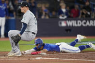 Toronto Blue Jays' Santiago Espinal scores on passed ball as Seattle Mariners relief pitcher Paul Sewald runs to cover the plate during the fifth inning of Game 2 of a baseball AL wild-card playoff series Saturday, Oct. 8, 2022, in Toronto. (Frank Gunn/The Canadian Press via AP)