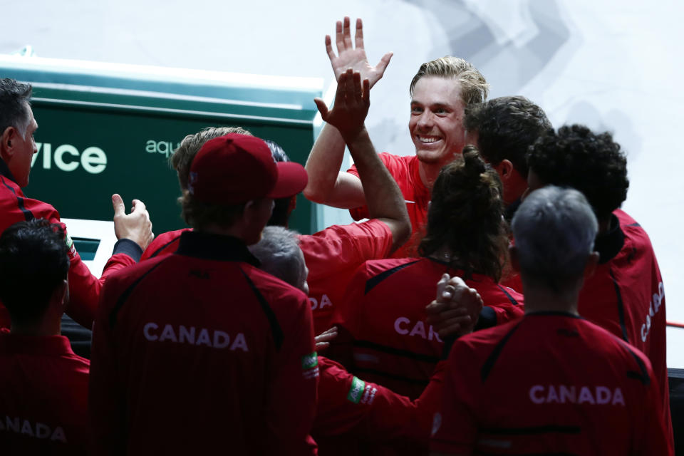 Canada's Denis Shapovalov, top center, celebrates with teammate after defeating Australia's Thanasi Kokkinakis during the final Davis Cup tennis match between Australia and Canada in Malaga, Spain, Sunday, Nov. 27, 2022. (AP Photo/Joan Monfort)