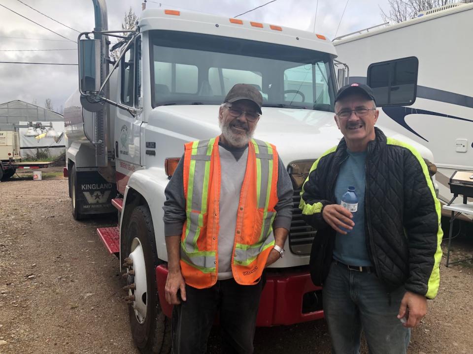 Brothers Alan and Mike Kimball stand in front of the hamlet's water truck they “borrowed” to fight the wildfire flames that encroached their homes in Enterprise, N.W.T.