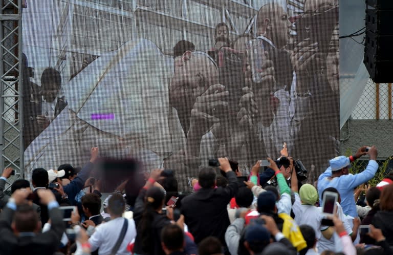 Pope Francis is seen on screen as he poses for a selfie at the Pontifical Catholic University of Ecuador, on July 7, 2015