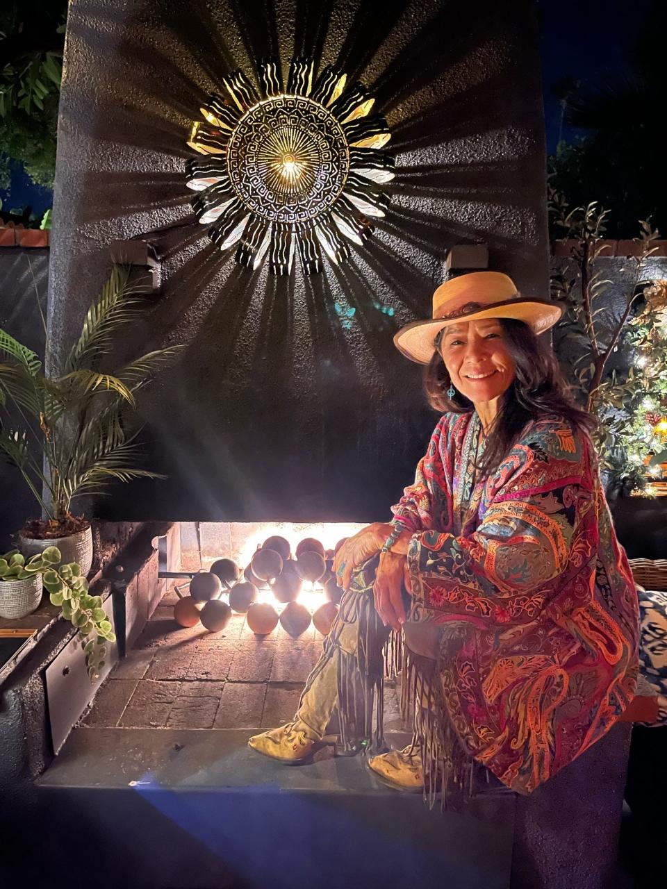At Villa Royale in Palm Springs, Sue Durazo is shown in front of one of her luminaries that cast a circle of shadows on a fireplace wall.