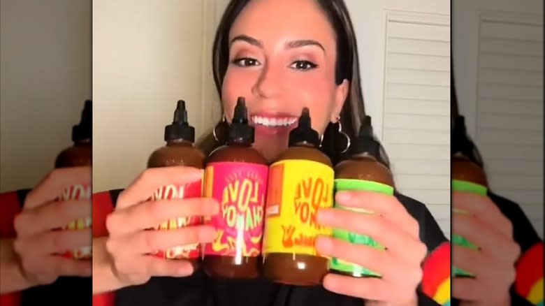 Annie Leal smiling and holding bottles of I Love Chamoy
