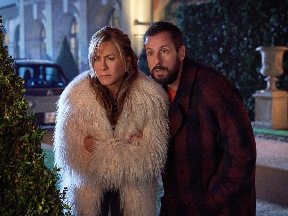 Jennifer Anniston in a coat standing next to Adam Sandler in a coat