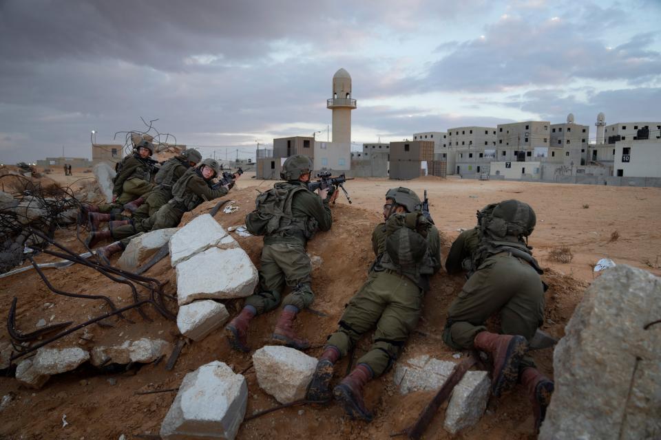 Israeli soldiers take positions during a training session simulating urban warfare at the Zeelim army base, southern Israel, Jan. 4, 2022.