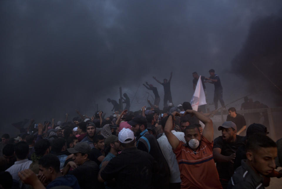 Palestinians chant angry slogans as they cut the fence during a protest at the Gaza Strip's border with Israel, Friday, Oct. 5, 2018. (AP Photo/Khalil Hamra)