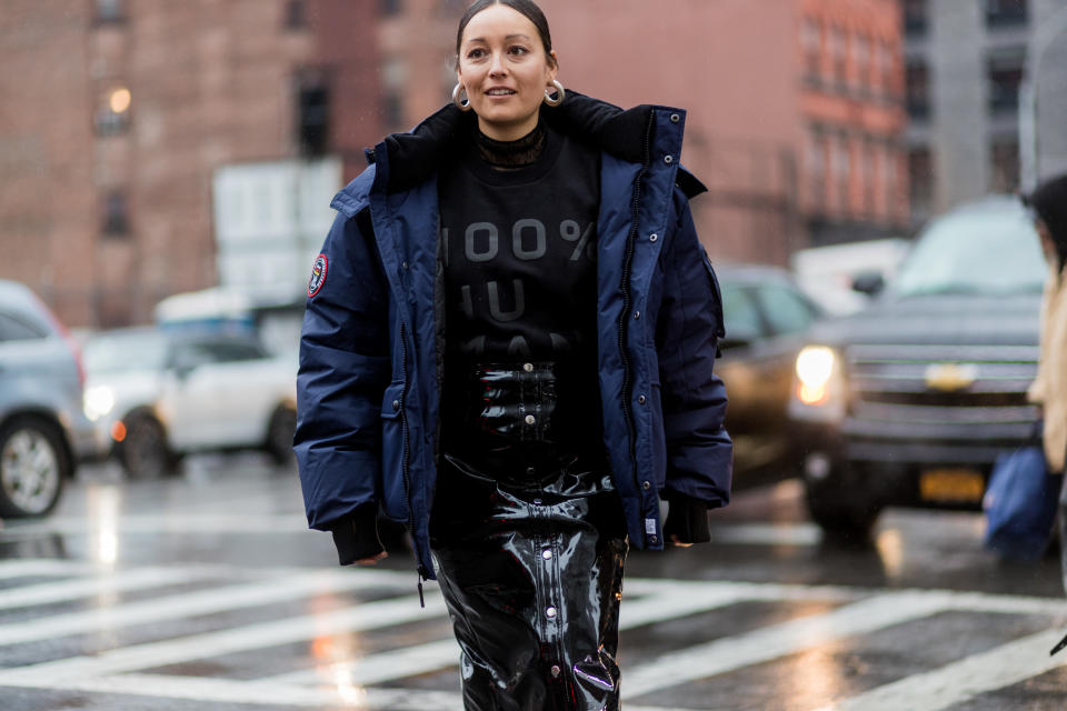 <p>Stylist Rachael Wang is wearing an Everlane T-shirt, navy puffer coat, and black patent-leather skirt. This is a chic and feminine way to mix and match unexpected textures while still looking haute-fashion in the cold. (Photo: Getty Images) </p>