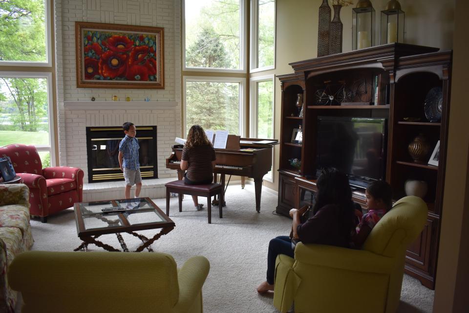 Caden's mother and sister sit in on the voice lesson and cheer after he finishes each song.