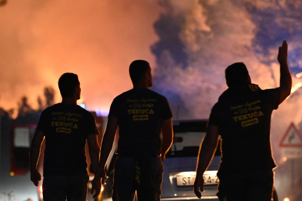 Smoke cloaks the street as a wildfire rages in Zaton, Croatia (AP)