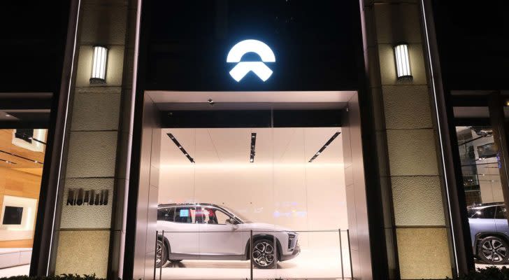 NIO stock: A shot from the outside of a Nio display room at night.