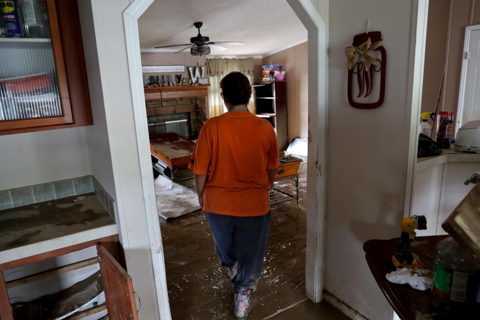 Teresa Watkins, 54, works to salvage belongings from her flood-damaged home outside of Jackson, Kentucky.