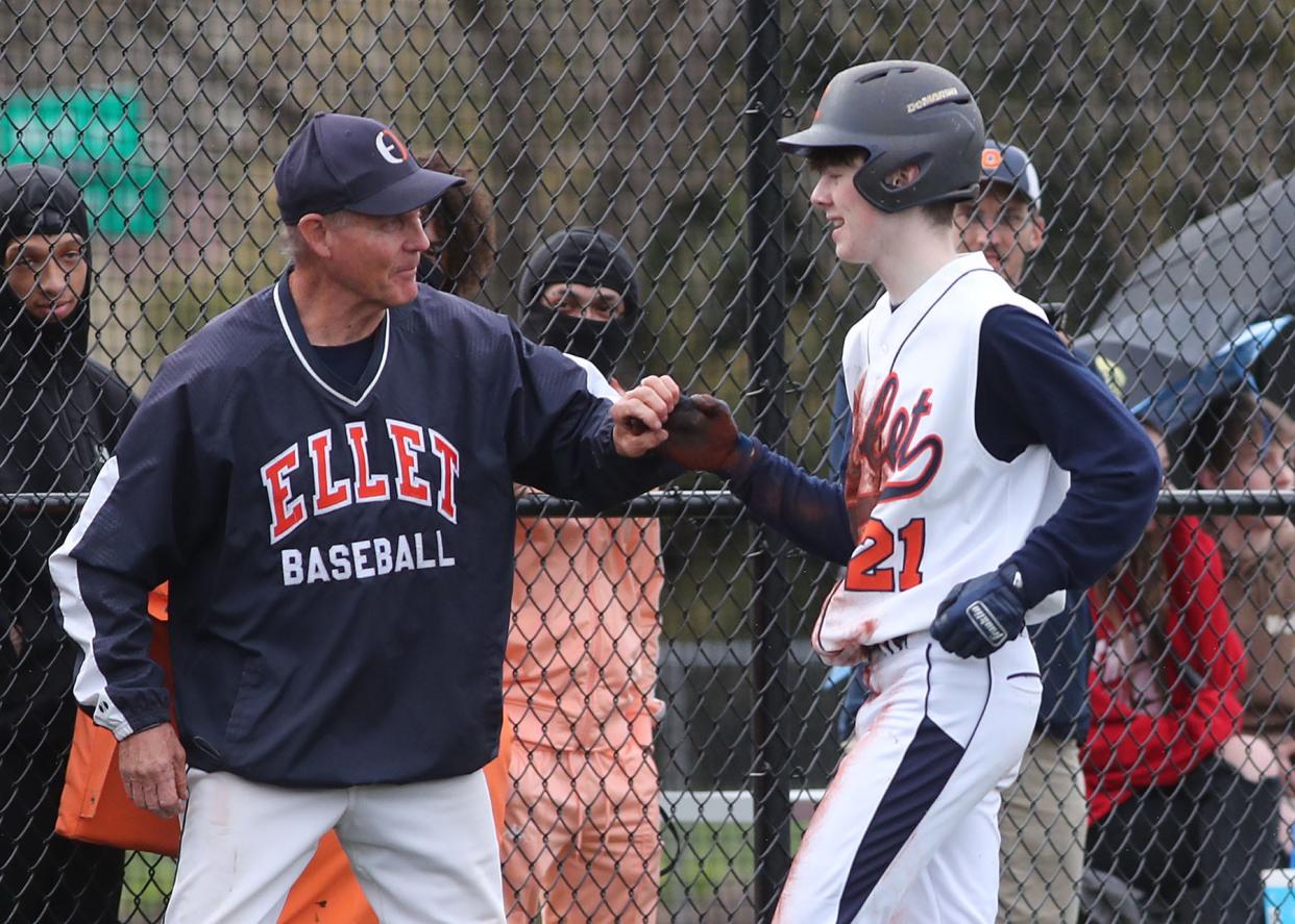 Ellet baseball coach John Sarver congratulates Chase Merring on driving in a run against Firestone at Ellet High School on Friday, April 22, 2022.