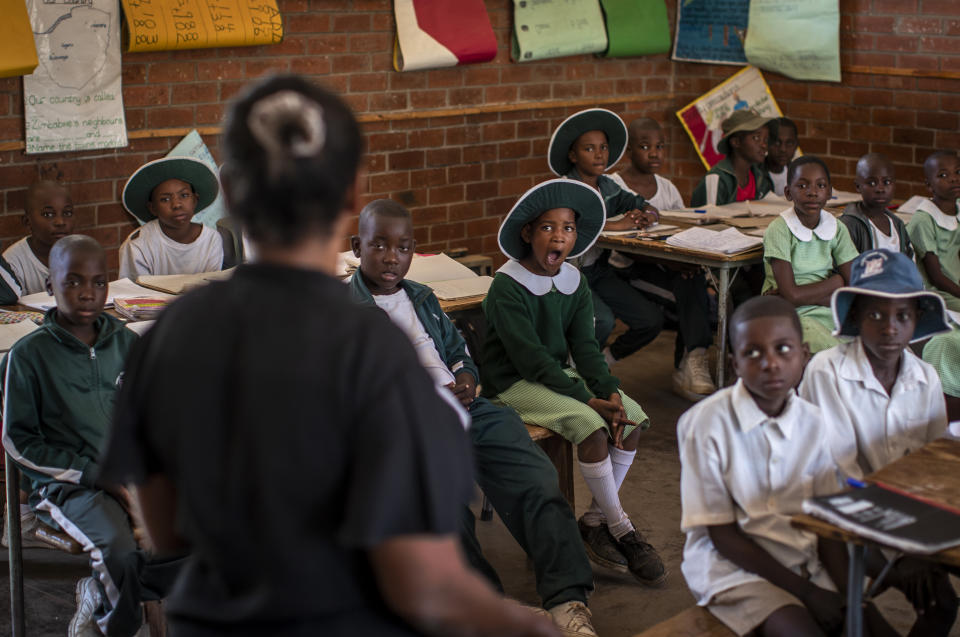 Schoolchildren attend a class in the Shona language on the first day of term at the Vimbai Primary School in Norton, west of the capital Harare, in Zimbabwe Tuesday, Sept. 10, 2019. Former president Robert Mugabe, who enjoyed strong backing from Zimbabwe's people after taking over in 1980 but whose support waned following decades of repression, economic mismanagement and allegations of election-rigging, is expected to be buried on Sunday, state media reported. (AP Photo/Ben Curtis)