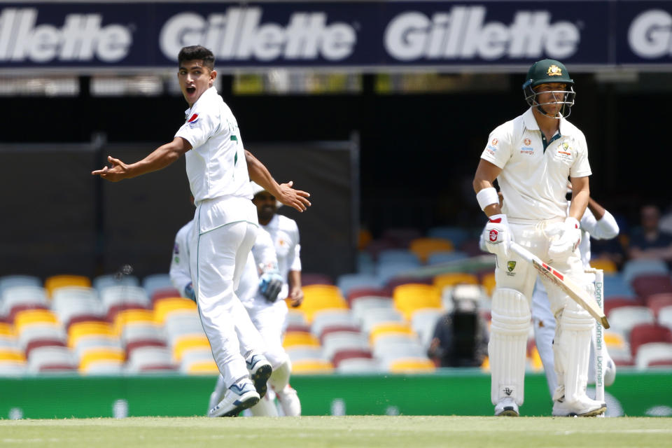 Pakistan's Naseem Shah, left, celebrates the wicket of Australia's David Warner, right, before the decision was overturned due to a no ball called during their cricket test match in Brisbane, Australia, Friday, Nov. 22, 2019. (AP Photo/Tertius Pickard)