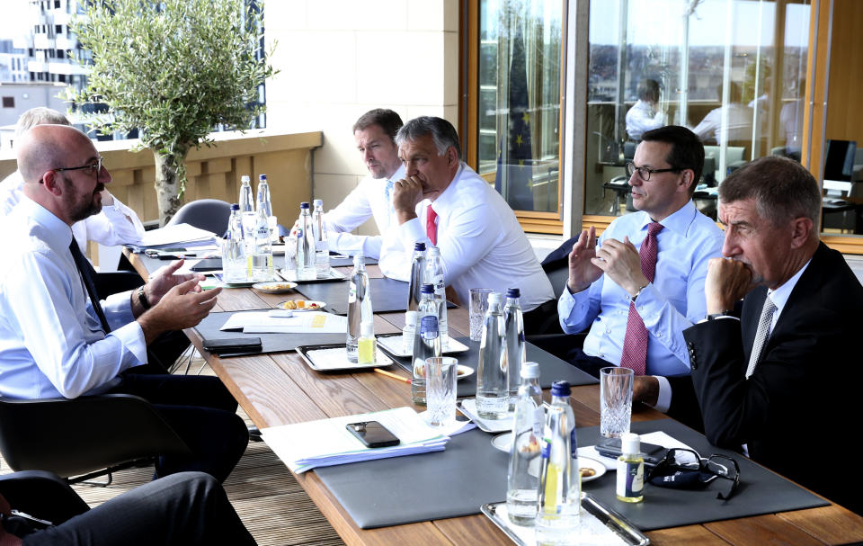 from left, European Council President Charles Michel, Slovakia's Prime Minister Igor Matovic, Hungary's Prime Minister Viktor Orban, Poland's Prime Minister Mateusz Morawiecki and Czech Republic's Prime Minister Andrej Babis meet on the sidelines of an EU summit at the European Council building in Brussels, Sunday, July 19, 2020. Leaders from 27 European Union nations meet face-to-face for a third day of an EU summit to assess an overall budget and recovery package spread over seven years estimated at some 1.75 trillion to 1.85 trillion euros.(Francois Walschaerts, Pool Photo via AP)