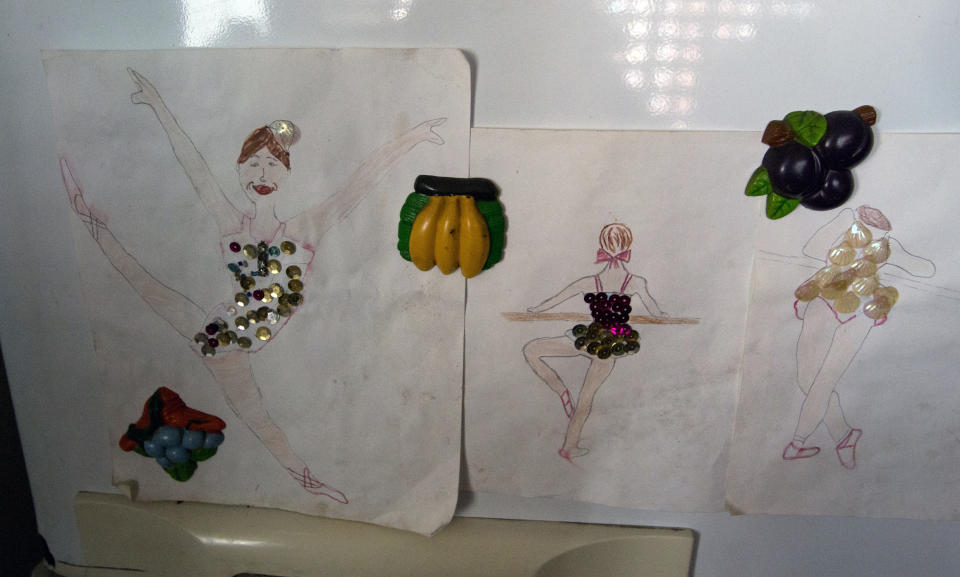 In this Dec. 17, 2018 photo, drawings of dancers made by Iraly Yanez's niece decorates her fridge, in Caracas, Venezuela. "Dancing is all about passion" said AM Danza's director. "You have to enjoy your possibilities and use your body to express emotions." (AP Photo/Fernando Llano)