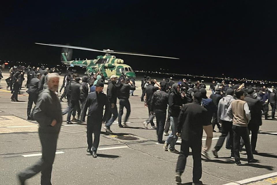 People in the crowd walk shouting antisemitic slogans at an airfield of the airport in Makhachkala, Russia, Monday, Oct. 30, 2023. Russian news agencies and social media say hundreds of people have stormed into the main airport in the Dagestan region and onto the landing field to protest the arrival of an airliner coming from Tel Aviv, Israel. (AP Photo)