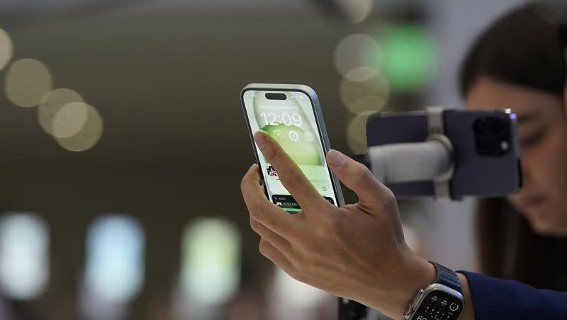 People look at iPhone 15 phones during an announcement of new products on the Apple campus in Cupertino, Calif., on Tuesday, Sept. 12, 2023.