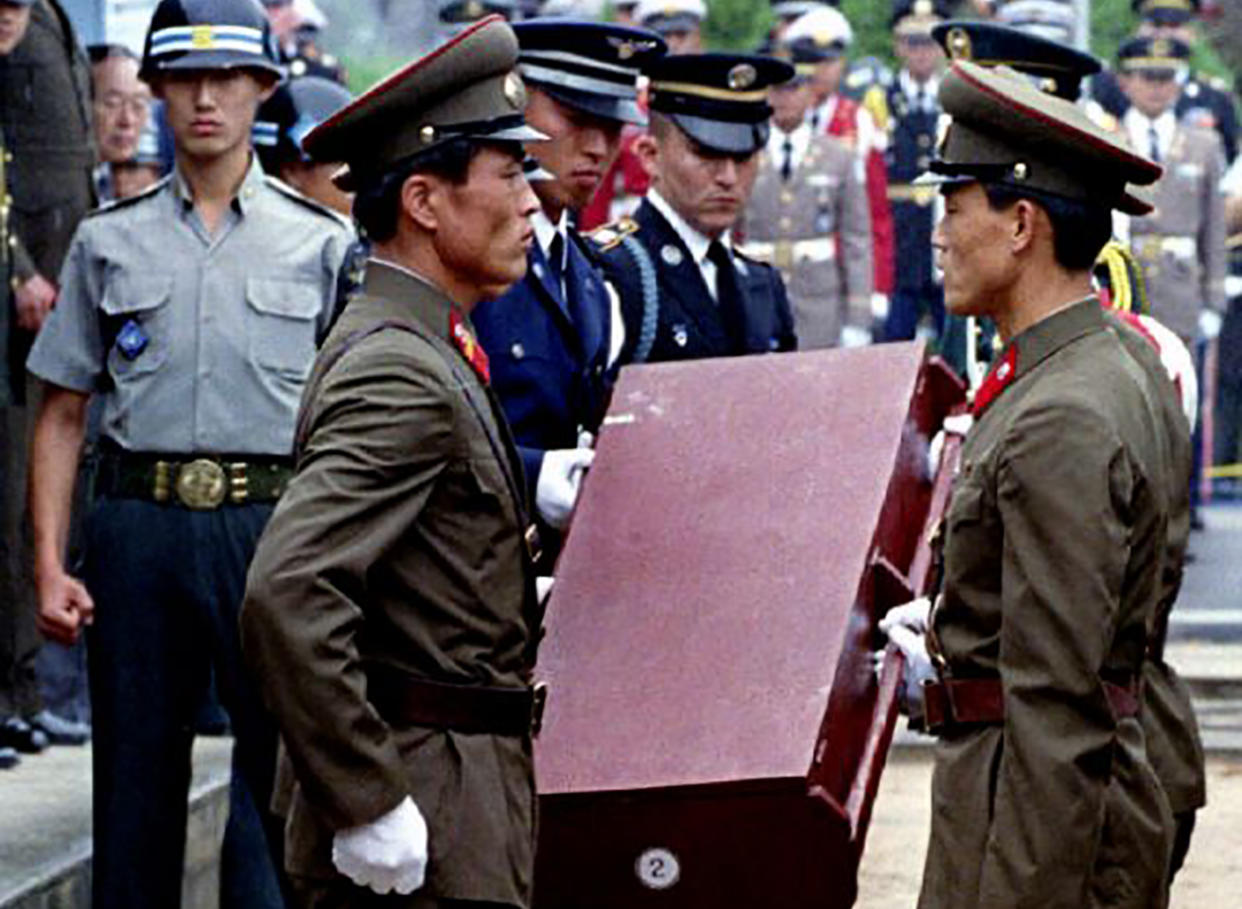 FILE PHOTO: North Korean soldiers hand over to United Nations troops standing at the North Korea / South Korea border a casket containing the remains of one of seventeen US servicemen who served in the 1950-53 Korean War during repatriation ceremonies at the treaty village of Panmunjom, North Korea, July 12, 1993. REUTERS/Jim Bourg/File Photo