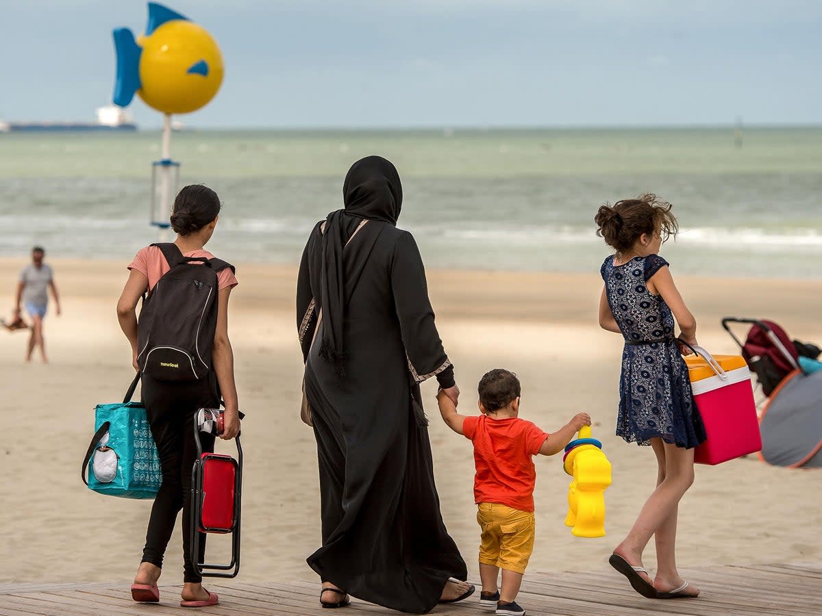 File photo of a woman wearing the abaya and walking with children on a beach in Malo-Les-bains, northern France in 2016  (AFP/Getty)