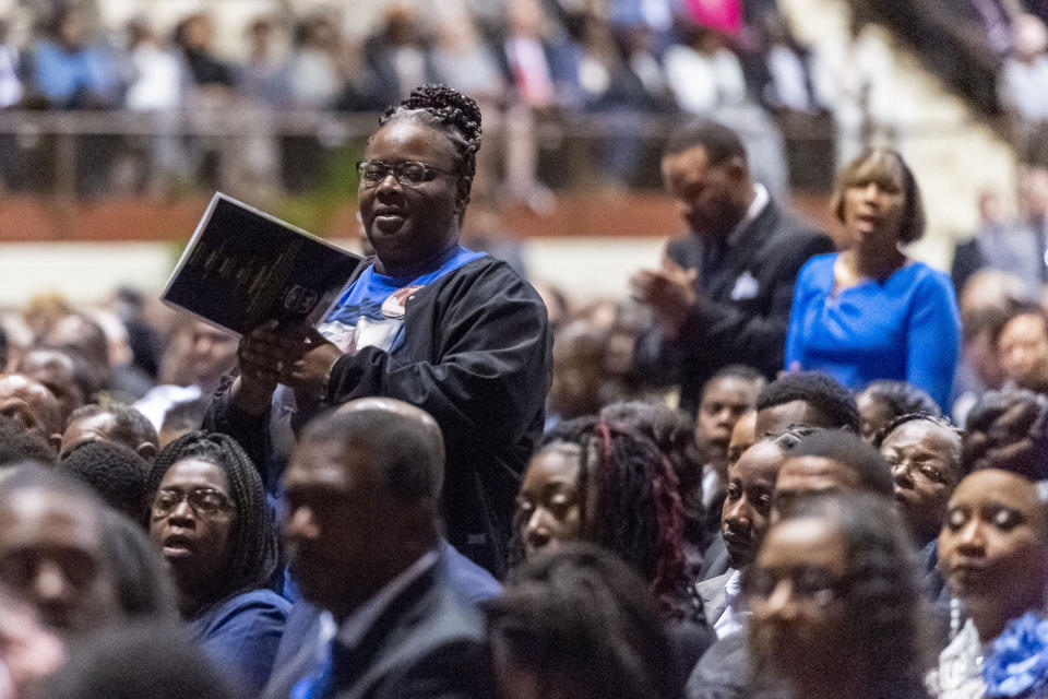 Mourners stand and clap as music plays during the memorial service for slain Lowndes County Sheriff John Williams, Monday, Dec. 2, 2019, in Montgomery, Ala. (AP Photo/Vasha Hunt)