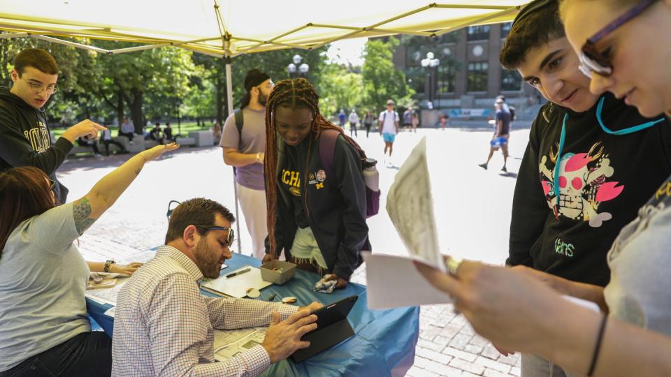 Deborah Sonoiki, 17, of Lagos, Nigeria (center) asks for directions at the information station on the Diag at the University of Michigan in Ann Arbor, Mich. on Tuesday, Aug. 29, 2023. Information stations are strategically placed around the campus to help direct students to classes and other resources after the internet went down on the University of Michigan campus. The Information Assurance team at the university shut down the internet at all the campuses on Sunday, Aug. 27 at 1:45 p.m. after a significant security concern was found.