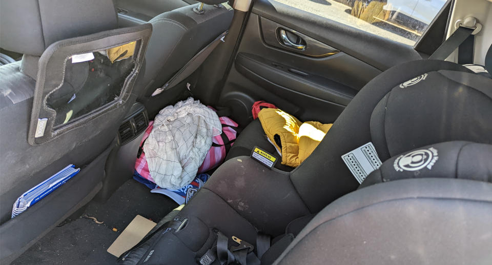 Inside car with car seat, bags and mirror on headrest