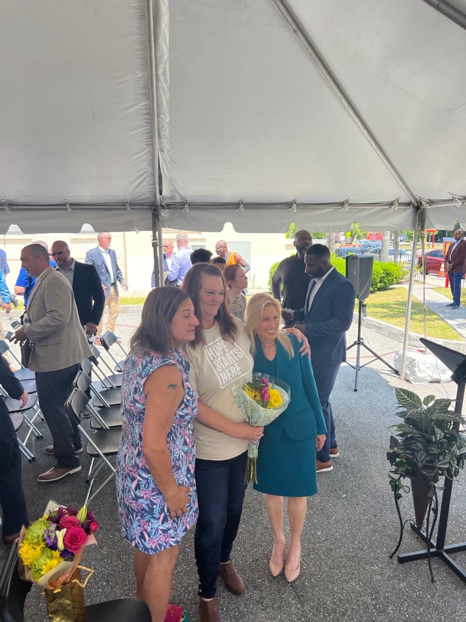 Ready2Work graduate Leigh Ann Bohrer, center, receives congratulatory hugs from Mayor Donna Deegan, right, and an unidentified woman at a recent graduation ceremony for the Operation New Hope program for ex-offenders.