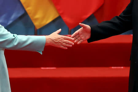 FILE PHOTO: Chinese President Xi Jinping welcomes German Chancellor Angela Merkel as leaders arrive for a group picture during the G20 Summit in Hangzhou, Zhejiang province, China September 4, 2016. REUTERS/Damir Sagolj/File Photo