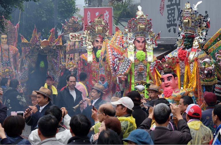 Taoist gods are surrounded by local residents during the annual 'Holy pig' festival outside the Zushi Temple in Shanhsia district of the New Taipei City, on February 24, 2015