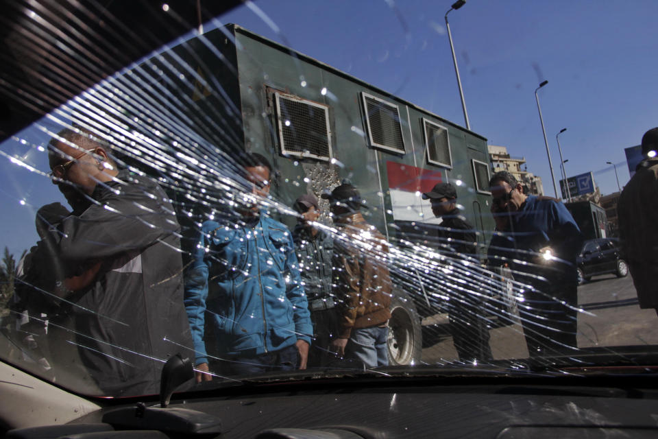 Egypt's security forces look through the shuttered windshield of a vehicle damaged after bomb explosions targeted at a checkpoint in Giza, Egypt, Friday, Feb. 7, 2014. Twin homemade bombs targeting a police checkpoint wounded several people on a bridge in Cairo's twin city of Giza Friday morning, the latest apparent attack by militants near the center of the Egyptian capital. (AP Photo/El Shorouk, Aly Hazzaa) EGYPT OUT