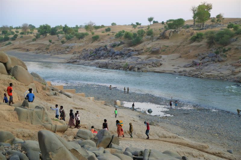 Ethiopians who fled the ongoing fighting in Tigray region, collect water from the Setit river on the Sudan-Ethiopia border in eastern Kassala state