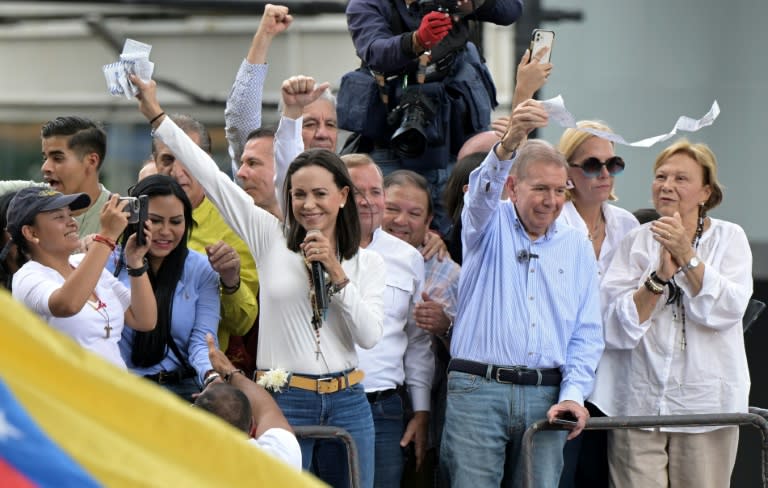 La líder opositora venezolana María Corina Machado (C) y el candidato presidencial opositor Edmundo González Urrutia agitan actas de votación durante un mitin frente a la sede de las Naciones Unidas en Caracas el 30 de julio de 2024 (Yuri CORTEZ)